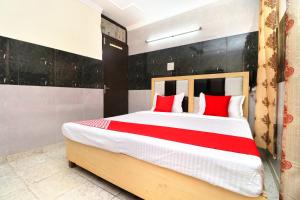 a bedroom with a large bed with red pillows at Flagship Hotel New Diamond in Sohāna