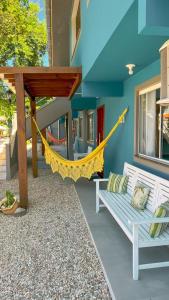 a porch with a hammock attached to a house at Vila Alegria in Bombinhas