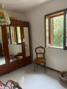 Habitación con silla y espejo. en Villa Kenia Flora, en Maratea