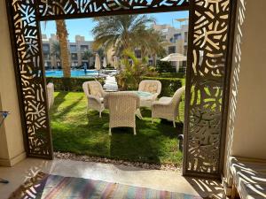 una puerta abierta a un patio con mesa y sillas en Mangroovy apartament El gouna, en Hurghada