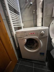 a bathroom with a washing machine and a toilet at Stan na dan Apartman TRG in Derventa