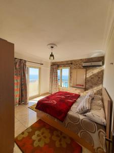 Una cama grande en un dormitorio con ventana. en City Square - Apartments With Side Sea-View, en Alejandría