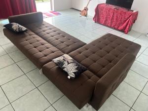 um sofá castanho sentado numa sala de estar em Stay'N Go em Uturoa