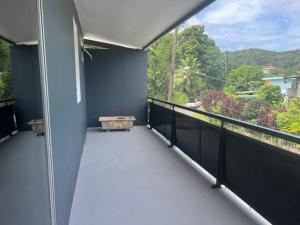 a balcony with a bench on the side of a building at Stay'N Go in Uturoa