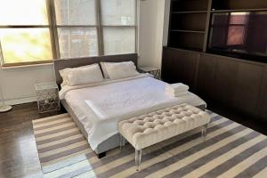 a bedroom with a large bed with a ottoman at Private Penthouse w Roof Oasis in New York