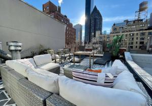 a rooftop patio with couches and tables on a building at Private Penthouse w Roof Oasis in New York