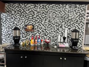 a counter in a kitchen with a black and white tile wall at Wingate by Wyndham North Little Rock in North Little Rock