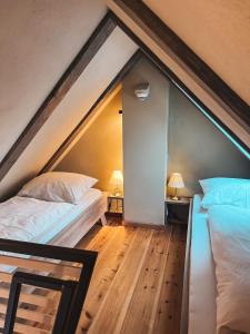 a attic bedroom with two beds and two lamps at Kyritzer Budenhaus (Nr. 109) in Kyritz