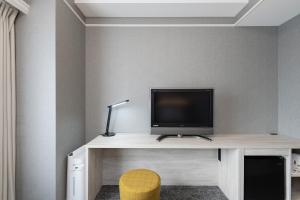 a desk with a tv and a lamp on it at The One Five Garden Kurashiki - Vacation STAY 40159v in Kurashiki