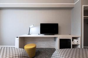 倉敷市にあるThe One Five Garden Kurashiki - Vacation STAY 40174vのデスク、テレビ、ベッドが備わる客室です。
