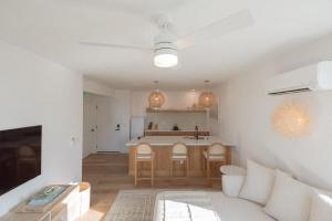a living room with a couch and a kitchen at The Atlantic at The Tarrymore in Wrightsville Beach +23 photos