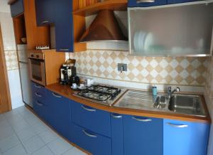 a blue kitchen with a sink and a stove at Bethel luxury fiumicino in Fiumicino