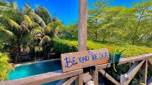 um sinal que diz "Bevind the sea on a wood cerca" em Hotel Jaiba Mahahual - Adults Only em Mahahual