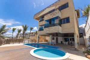 a villa with a swimming pool and a resort at Seaside #16 - Flat em Ponta Negra por Carpediem in Natal