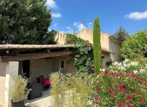 een tuin met bloemen en planten voor een huis bij Le Mas Relax in Cavaillon