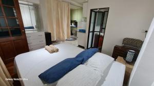 苏瓦Cosy 2 bedroom unit with pool,Wifi的卧室里有一张床，上面放着蓝色的枕头 更多37张照片
