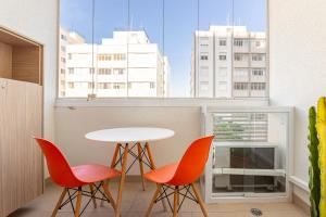 1 mesa y 2 sillas en una habitación con ventana en ESD - E-Side Vila Madalena - Anora Spaces Residenciais, en São Paulo
