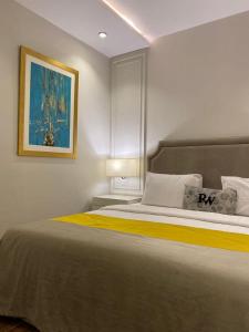 拉合爾的住宿－Rosewood Lahore，卧室配有一张大床,墙上挂有绘画作品