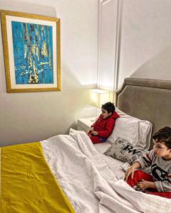 two young boys sitting on a bed at Rosewood Lahore in Lahore