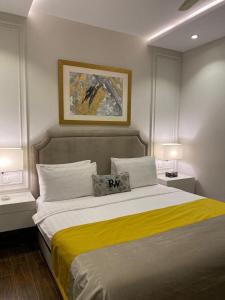 a bedroom with a large bed with a yellow blanket at Rosewood Lahore in Lahore