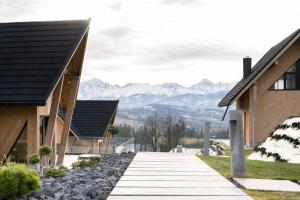 a walkway between two buildings with mountains in the background at Chaletovo Mountain Residences in Zakopane