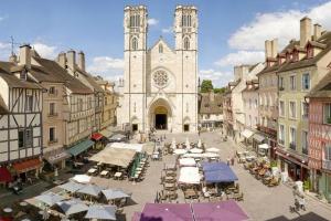 eine Altstadt mit einer Kirche und eine Straße mit Tischen in der Unterkunft Charmant appartement centre ville avec cour in Chalon-sur-Saône