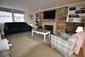 a living room with a couch and a fireplace at St Annes Crail- grand family home in Crail