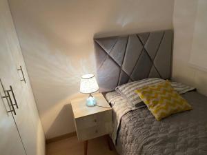 1 dormitorio con cama y mesita de noche con lámpara en Apartamento en Barranco, en Lima