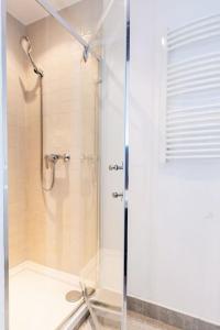 a shower with a glass door in a bathroom at Elegant and cozy in the amazing part of downtown in Warsaw