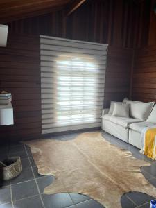 uma sala de estar com um sofá e uma janela em Chalé aconchegante em Itu