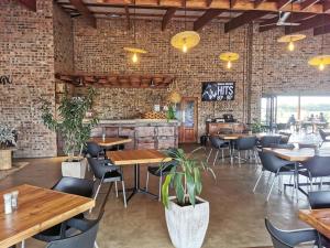 a restaurant with tables and chairs and a brick wall at Tinswari Self-catering Chalet in Hluhluwe