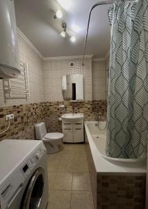 uma casa de banho com uma máquina de lavar roupa e um WC em 2х кімн новобудова Герцена-парк Шевченка em Chernivtsi