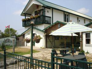 a table with an umbrella in front of a building at Safari Getaway in Orono