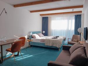 1 dormitorio con cama, sofá y mesa en Atrium New Gudauri by Gudauri Travel, en Gudauri