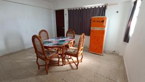 ein Esszimmer mit einem Tisch und Stühlen sowie einem Kühlschrank in der Unterkunft Hotel Tropical in Progreso