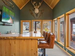 uma sala de jantar com uma grande mesa de madeira e cadeiras de couro em Longbow Lodge em Walker