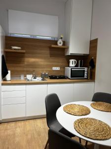 a kitchen with a table with chairs and a microwave at La Maison Luxury in Lamía