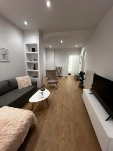 a living room with a couch and a tv at La Maison Luxury in Lamía