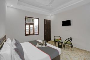 um quarto de hotel com uma cama e uma televisão em The Royal Fern em Farrukhnagar