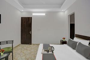 een hotelkamer met een wit bed en een tafel bij The Royal Fern in Farrukhnagar