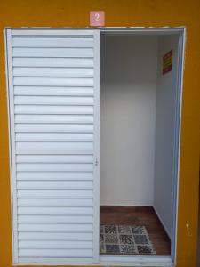 uma grande porta branca de garagem num quarto em Pousada Believe na Praia Grande