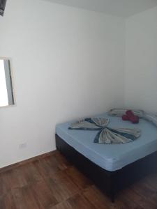 a bed sitting in a corner of a room at Pousada Believe in Praia Grande