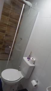 a white bathroom with a toilet and a sink at Pousada Believe in Praia Grande