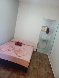 a small room with a bed and a glass wall at Pousada Believe in Praia Grande