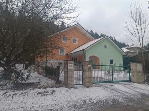 a house with a fence in the snow at Pension Eva in Domažlice