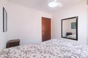ein weißes Schlafzimmer mit einem Bett und einem Spiegel in der Unterkunft Linda casa c Wi-Fi a 400m da Praia de Xangri-la RS in Xangri-lá