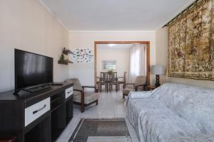 Schlafzimmer mit einem Bett und einem Flachbild-TV in der Unterkunft Linda casa c Wi-Fi a 400m da Praia de Xangri-la RS in Xangri-lá