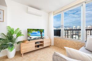uma sala de estar com televisão e uma grande janela em Apartamento Currus Miramar Playa em Benidorm