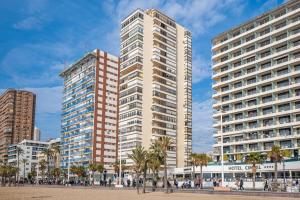 two tall buildings in a city with palm trees at Apartamento Currus Miramar Playa in Benidorm