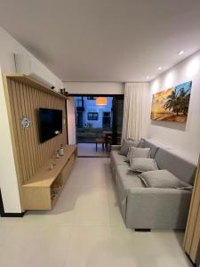 salon z kanapą i telewizorem z płaskim ekranem w obiekcie Praia do Forte - Villa do Lago w mieście Praia do Forte
